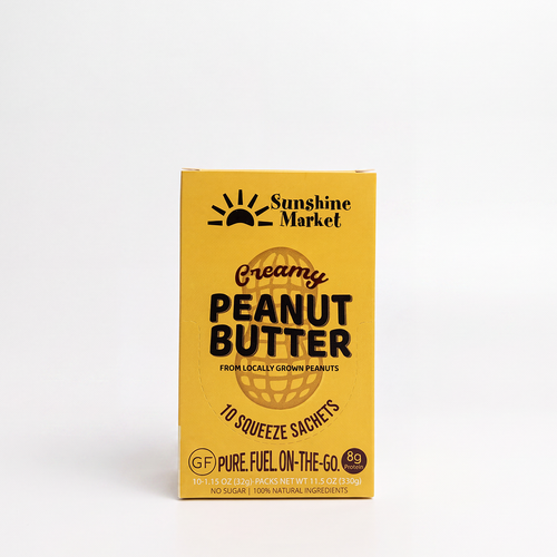 A yellow box of Sunshine Market Creamy Peanut Butter 10 squeeze sachets, 100% natural peanut butter