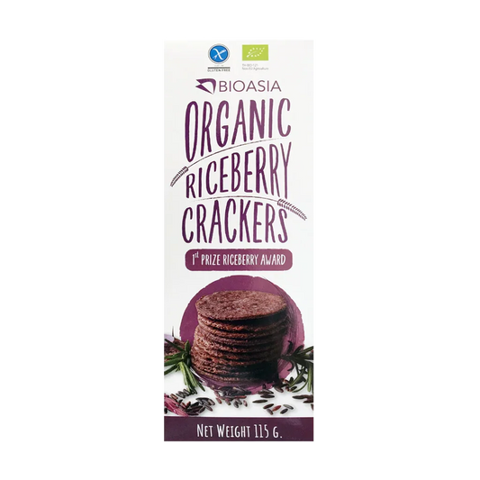 Bioasia Organic Riceberry Crackers packaging box, featuring a white background with purple text, a stack of dark brown riceberry crackers, and green and blue organic certification logos at the top.